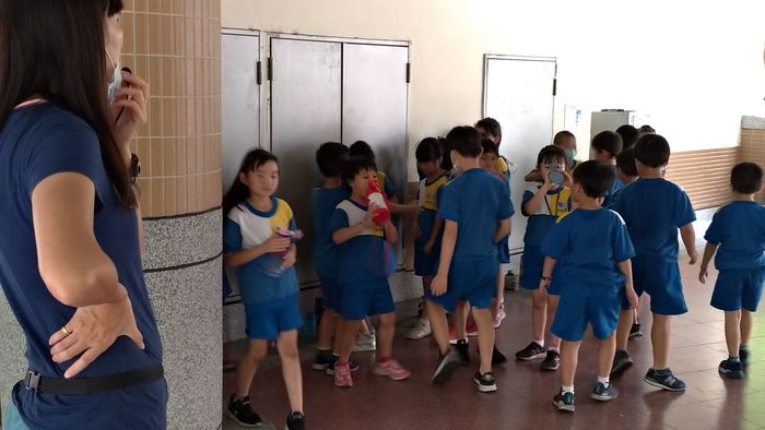 體育老師指導學生，運動後補充水分